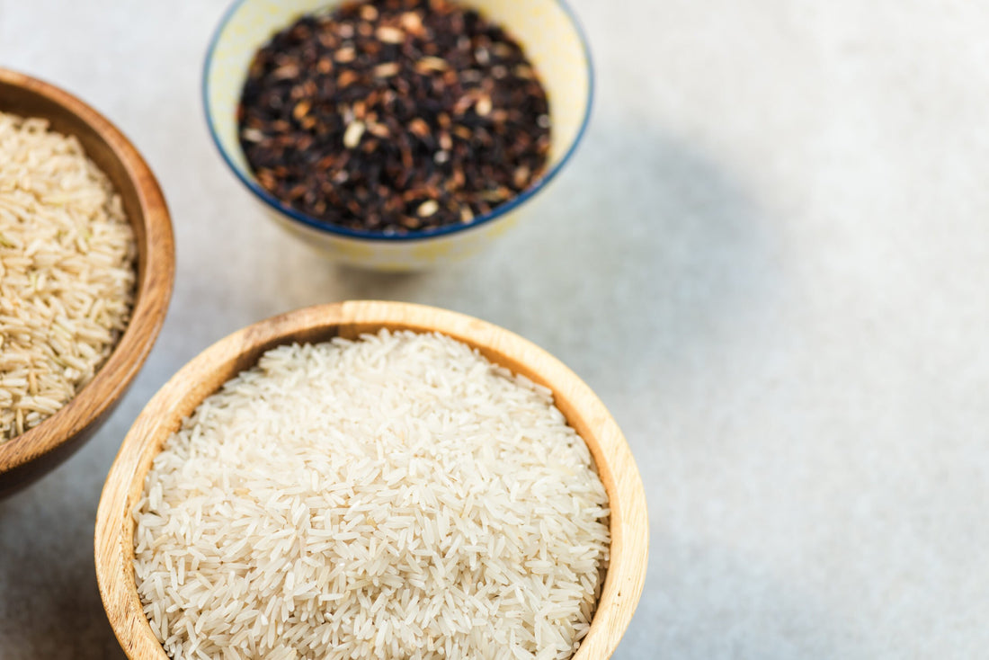 Different types of rice in wooden bowls such as basmati, brown a